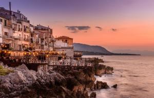 un gruppo di edifici sul bordo dell'acqua di Favolosa Casa Vacanza a Cefalù a Cefalù