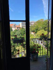 a view through a window of a house with a balcony at Hospedaria Boavista in Porto