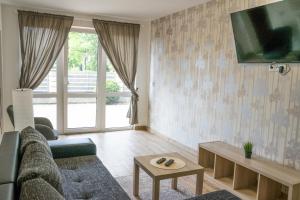 salon z kanapą i telewizorem na ścianie w obiekcie Penzion u lázní w mieście Velké Losiny