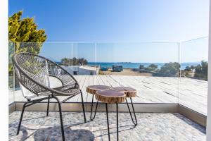 einen Stuhl und einen Stuhl auf einem Balkon mit Meerblick in der Unterkunft Evdokia in Plaka