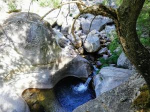 a stream of water in the middle of some rocks at Casa do Fundo do Povo - Serra da Estrela in Cortes do Meio