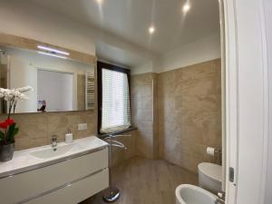 ein Badezimmer mit einem Waschbecken, einem WC und einem Spiegel in der Unterkunft Suite Saffi 99 in Viterbo