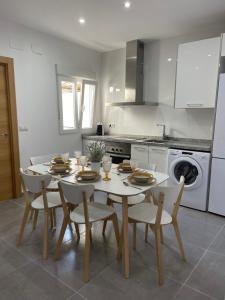 a kitchen with a white table and chairs and a kitchen with a stove at UIM Mediterraneo Segorbe 1 Wifi in Puerto de Sagunto