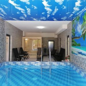 a swimming pool in a house with a blue ceiling at Vila Čair DOPLATA ZA BAZEN in Soko Banja