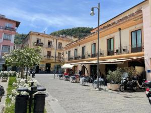 uma rua numa cidade com mesas e cadeiras em Blurooms em Sorrento