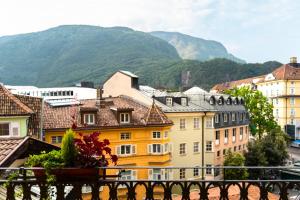 un grupo de edificios con montañas en el fondo en Feichter Hotel & Bistro, en Bolzano