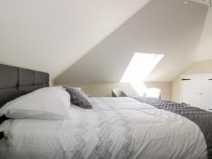 a bedroom with a large white bed with a window at The Hayloft in Bodmin
