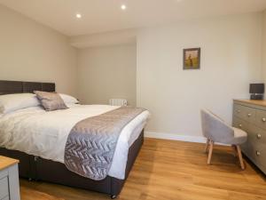 1 dormitorio con cama, escritorio y silla en The Cornstore, en Bodmin