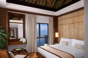 a bedroom with a bed and a large window at Golden Palm Tree Sepang in Sepang