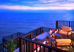 a balcony with a view of the ocean at night at Golden Palm Tree Sepang in Sepang