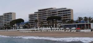 een strand met witte stoelen en een groot gebouw bij Great Waterfront Apartment In Cannes BoccaCabana in Cannes