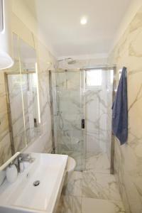 a white bathroom with a shower and a sink at Holiday house Punta in Umag
