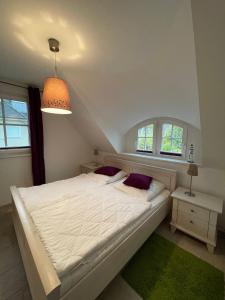a bedroom with a white bed and two windows at Mueggenburger Weg 46 Wohnung 3 Auszeit in Groß Kirr