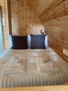 a bed in a wooden room with two towels on it at Allt Yelkie Pod Coig, Earlish in Earlish
