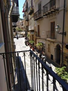 een balkon met uitzicht op een straat met gebouwen bij Casa Spinuzza 4 in Cefalù