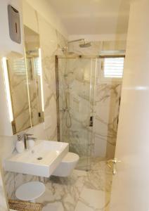 a white bathroom with a sink and a shower at Holiday house Punta in Umag