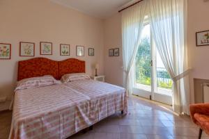 sypialnia z łóżkiem i dużym oknem w obiekcie Villa Donna Elisa Sorrento w Sorrento