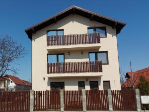 a white house with a wooden fence in front of it at Pensiunea Albina in Sînnicoară