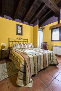 Un dormitorio con una cama con una manta. en Casa Rural Laura en Miranda del Castañar
