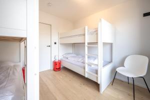 - une chambre avec des lits superposés et une chaise dans l'établissement dedijk, à Ostende