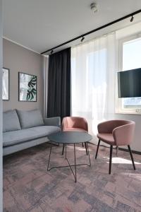 uma sala de estar com um sofá e duas cadeiras e uma mesa em Hotel Fridhem em Estocolmo