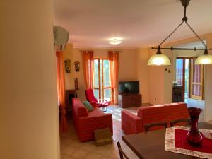 sala de estar con 2 sillas rojas y TV en A CASA MIA en Sperlonga
