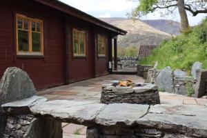 a dog laying on a stone wall in front of a building at Lodge 37 Rowardennan, Loch Lomond in Glasgow