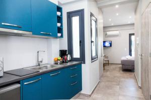 een keuken met blauwe kasten en een wastafel bij D Spacious Brand New Studio Ideal for 2 D in Athene
