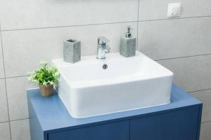 een witte wastafel op een blauwe kast in een badkamer bij D Spacious Brand New Studio Ideal for 2 D in Athene