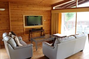 ein Wohnzimmer mit 2 Sofas und einem TV in der Unterkunft Lodge 37 Rowardennan, Loch Lomond in Glasgow