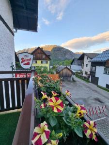 a balcony with flowers on the side of a building at Pension Bergfried in Hallstatt