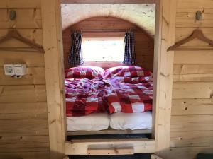 a bed in a log cabin with a window at SCHLAFFASS-DORF Restaurant am Golfplatz GC Pischelsdorf Gut Kaltenhausen - Motorradfahrer WILLKOMMEN! 