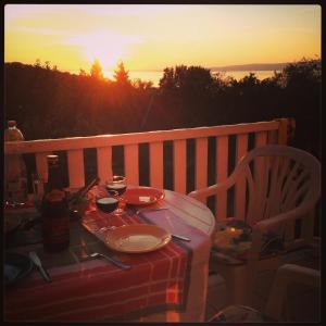 einen Tisch mit einer Mahlzeit auf dem Balkon bei Sonnenuntergang in der Unterkunft Martha apartman in Fonyód