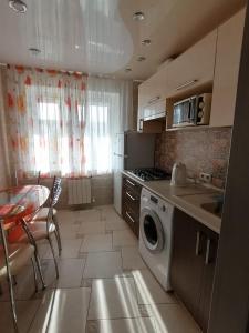 ヴォルシスキーにあるАпартаменты на Мира 47のキッチン(洗濯機、テーブル付)