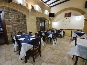 a restaurant with tables and chairs and a clock on the wall at Nonna Lucia in San Giorgio Ionico