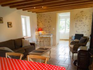 ein Wohnzimmer mit einem Sofa und einem Tisch in der Unterkunft Gîte Le p'tit nid de Montachon, Saulieu, Morvan in Saint-Didier