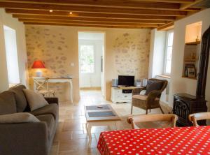 ein Wohnzimmer mit einem Sofa und einem Tisch in der Unterkunft Gîte Le p'tit nid de Montachon, Saulieu, Morvan in Saint-Didier