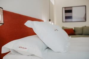 a pile of pillows sitting on top of a bed at La Ermita Suites - Único Hotel Monumento de Córdoba in Córdoba