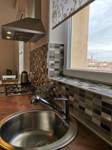 um lavatório de aço inoxidável numa cozinha com uma janela em Apartment Roman em Betina