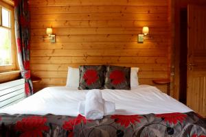 a bedroom with a bed with towels on it at Lodge 38 Rowardennan , Loch Lomond in Glasgow