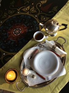 a table with a plate with a bowl and a tea pot at At Home In Maremma in Istia dʼOmbrone