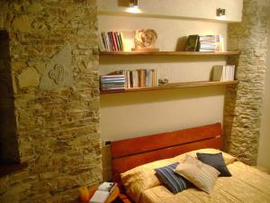 a bedroom with a bed and a shelf with books at Il Picco in Dronero