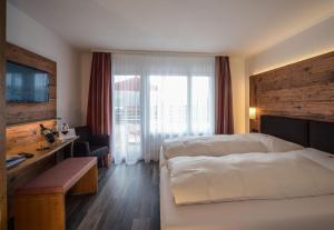 Pokój hotelowy z łóżkiem i biurkiem w obiekcie Hotel Brienz w mieście Brienz