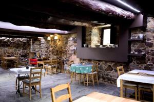 La Casa Grande Del Valle في El Valle: مطعم بطاولات وكراسي وجدار حجري