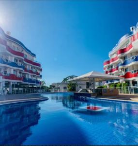 una piscina frente a algunos edificios de apartamentos en Holiday Ingleses Florianópolis, en Florianópolis