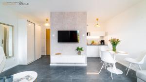 kuchnia i salon z telewizorem na ścianie w obiekcie Wonder Home - Apartamenty położone blisko deptaka, licznych restauracji i sklepów w mieście Karpacz