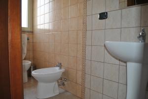 a bathroom with a toilet and a sink at Raxul Room in Sestu