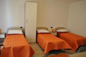 2 camas en una habitación con sábanas de color naranja en Raxul Room, en Sestu