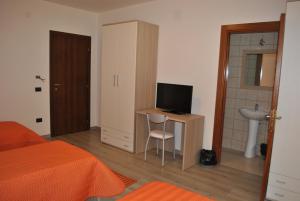 Un dormitorio con una cama y un escritorio con televisión. en Raxul Room, en Sestu 23 fotos más