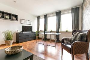 a living room with a couch and a tv at Schäfers Hotel in Cloppenburg